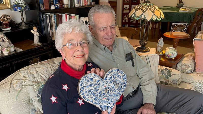 Carol and Bob Kaltenhauser hold a heart which features words of interests they share. Carol's daughter made the heart.
